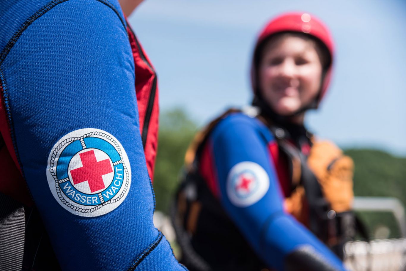 Zwei Mitgliederinnen der Wasserwacht sprechen im Neoprenanzug lachend miteinander